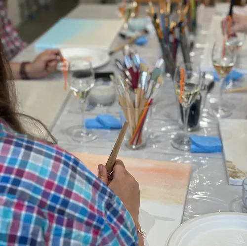 Person malt an einem Workshop-Tisch.