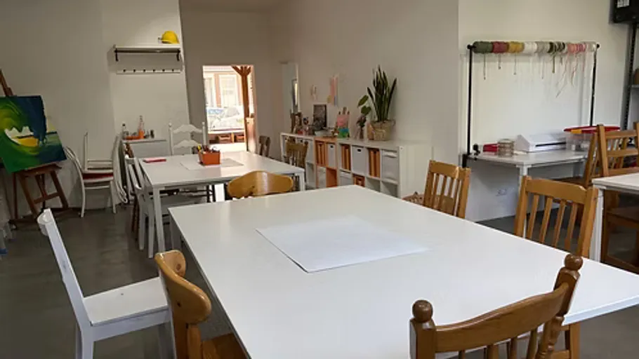 Creative studio with tables and art supplies.