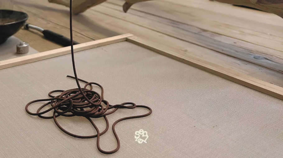 Braune Schnur spiralisiert auf Netzoberfläche, Holz Hintergrund.