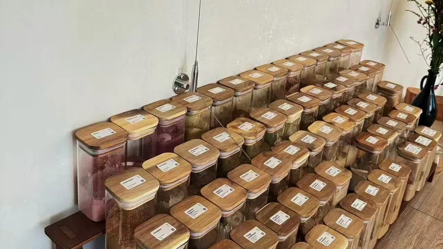 Stacked jars with labels on shelves.