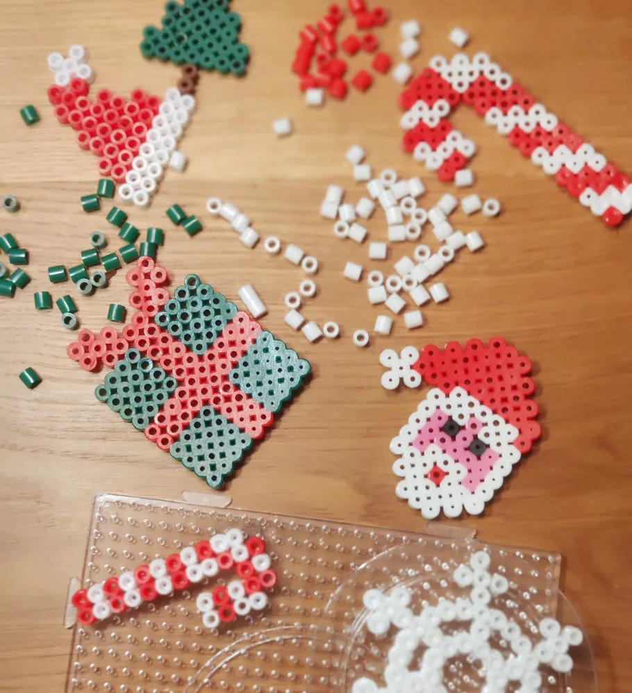 Colorful holiday-themed beads arranged on wooden table.