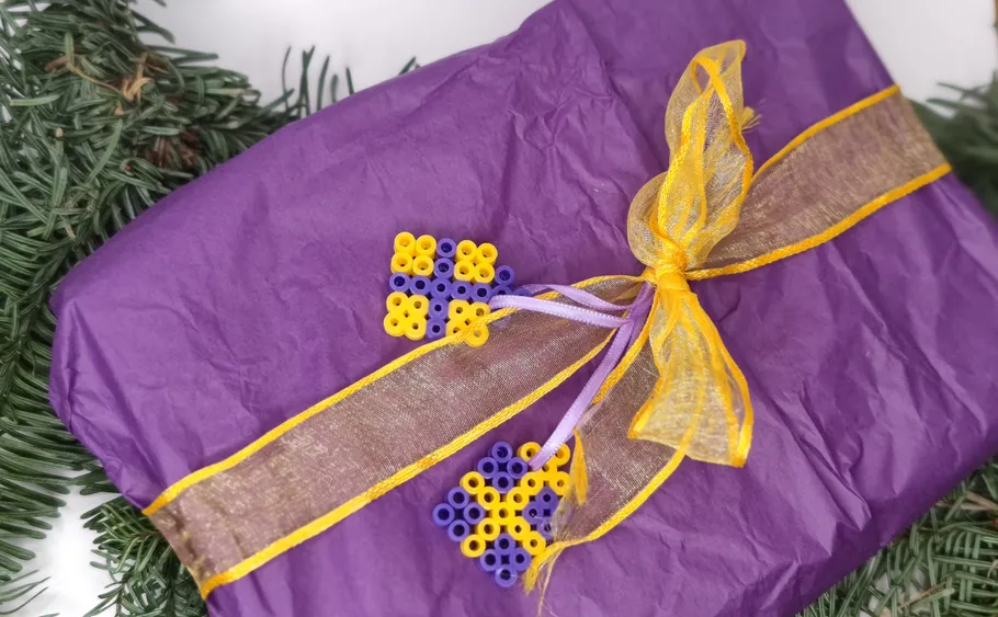 Purple gift with yellow ribbon, green branches.