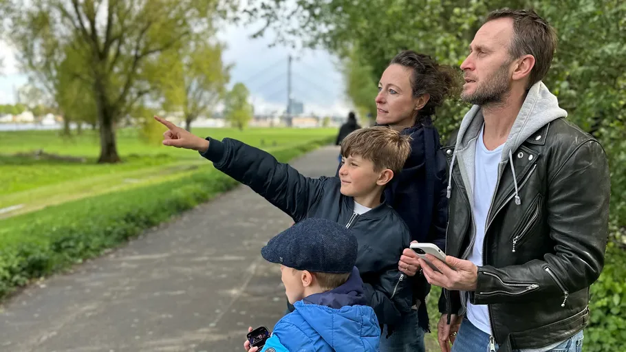 Family pointing and walking in a park.