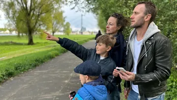 Family pointing and looking in park.