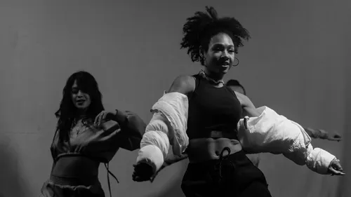 Two women dancing energetically indoors.