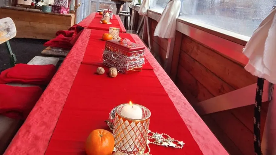Long table with red tablecloth and decorations.