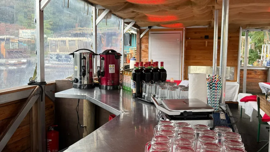 Outdoor bar with drinks and glasses on counter.