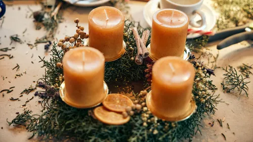 Four candles on a festive wreath table.