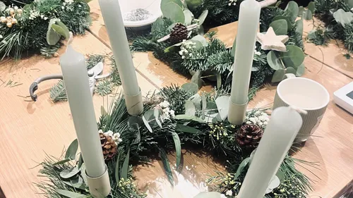 Candles on green wreath with decor items.