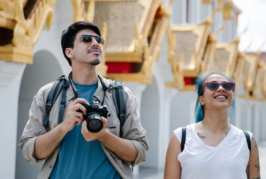 Zwei Touristen mit Kamera erkunden Tempel.