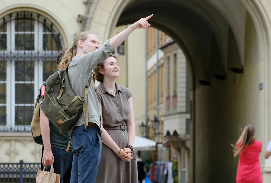 Two people pointing in city archway.