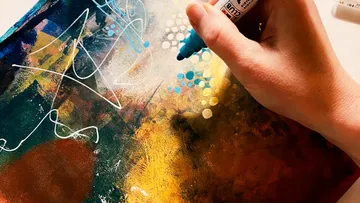 Hand zeichnet mit Marker auf abstraktem Gemälde.