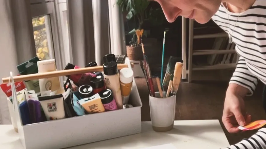 Person painting in a brightly lit room.