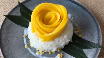 Mango rose atop sticky rice dessert.