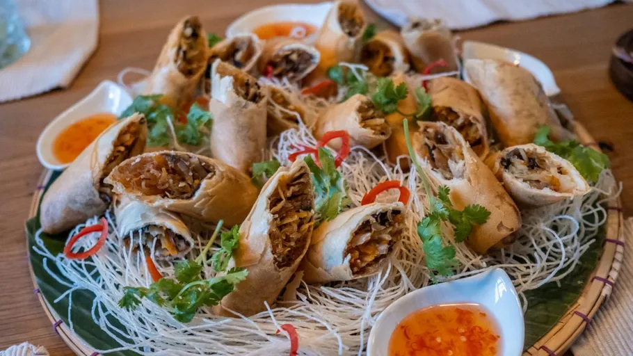 Spring rolls on plate with sweet chili sauce.