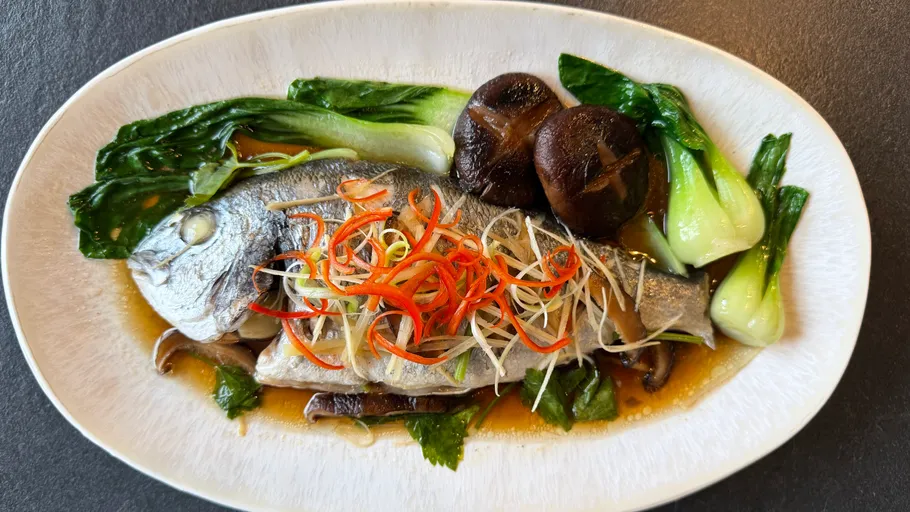 Cooked fish with vegetables on a plate.