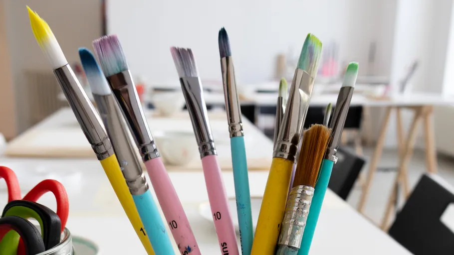 Paintbrushes in a holder on a table.