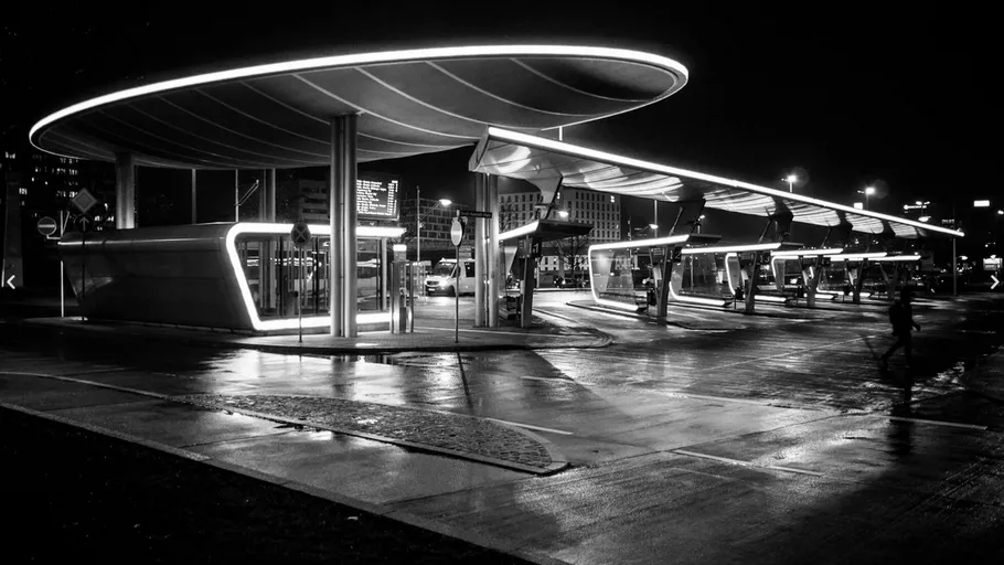 Modern bus station illuminated at night.