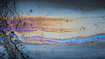 Oil spill creating rainbow effect on pavement.