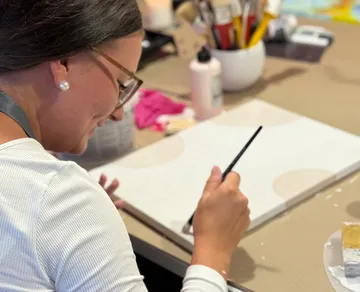 Person painting on canvas in art studio.