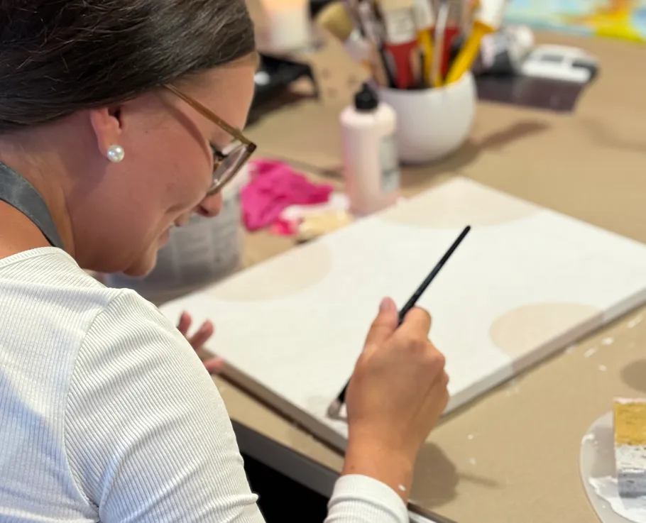 Person painting on canvas in art studio.