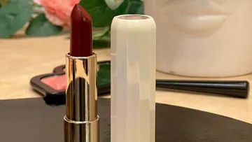 Roter Lippenstift geöffnet auf einem Schminktisch.