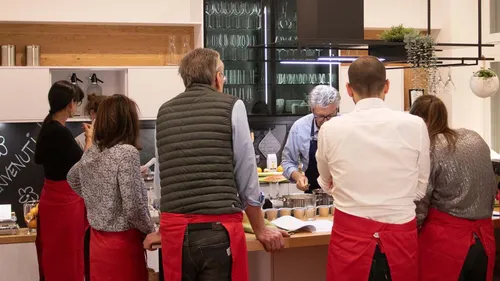 People in aprons attending a cooking class.