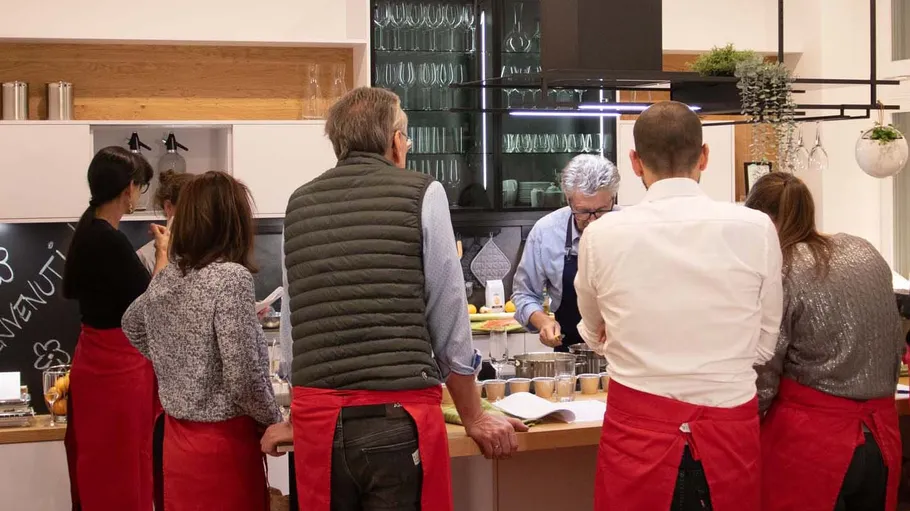 People in aprons attending a cooking class.