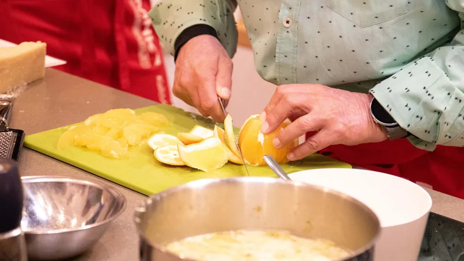 Person slicing oranges on a cutting board.
