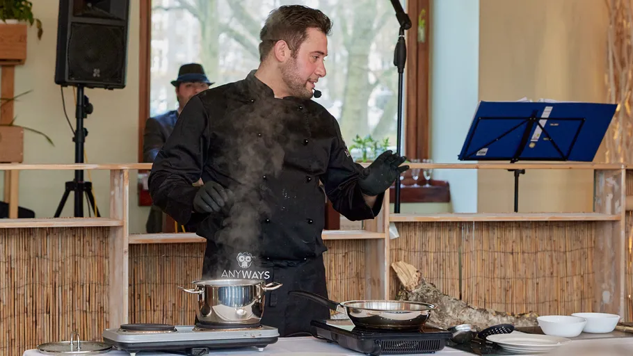 Koch kocht mit Dampf in einer Küche.