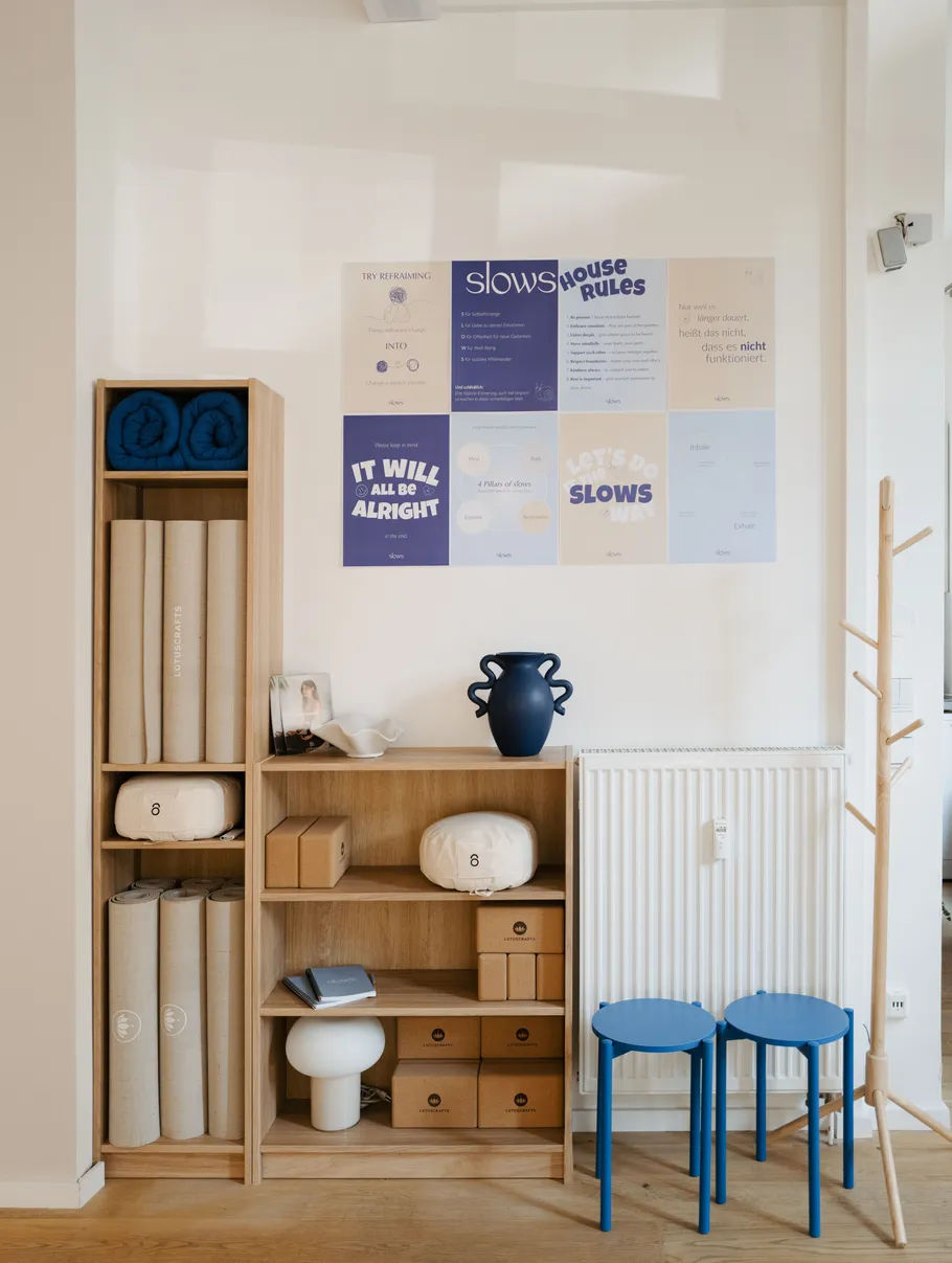 Shelf with yoga mats and blue stools.