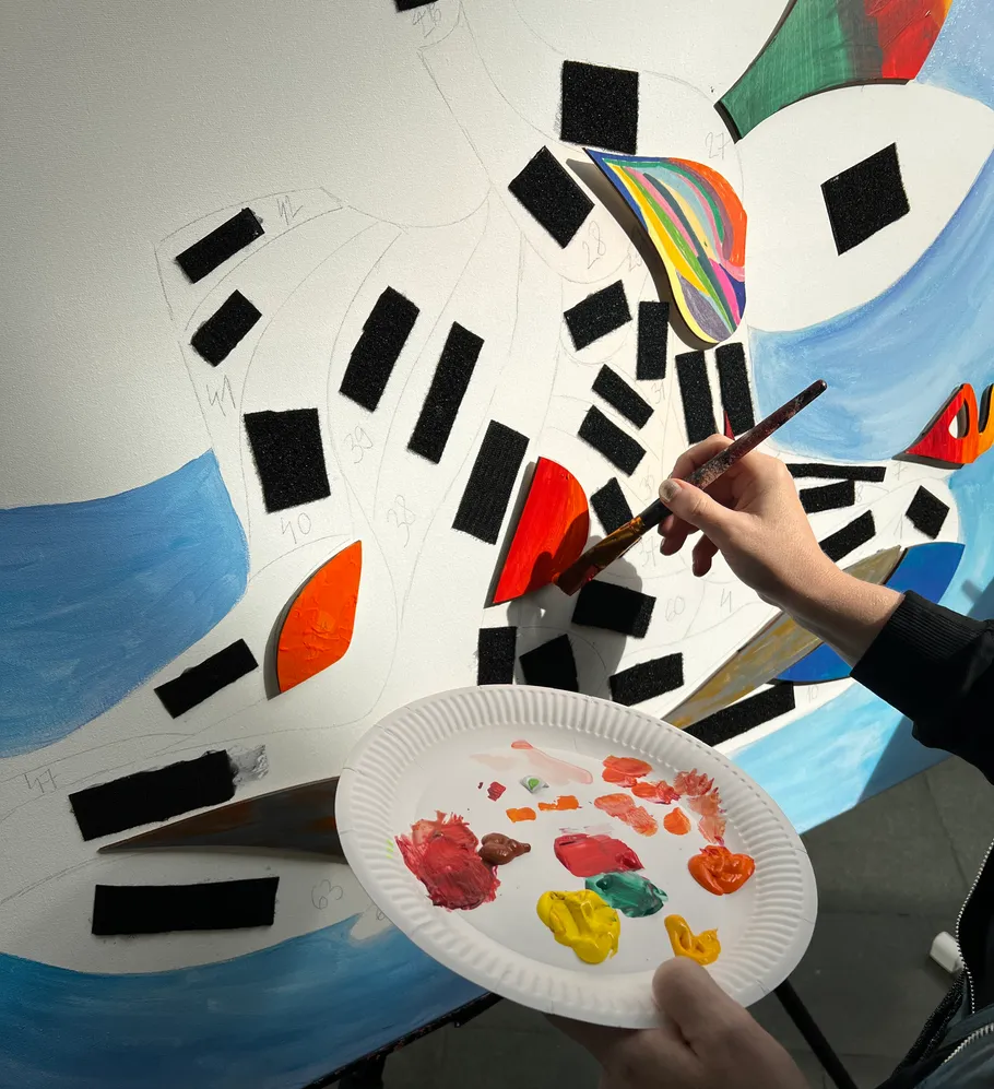 Person malt buntes abstraktes Kunstwerk auf Leinwand.