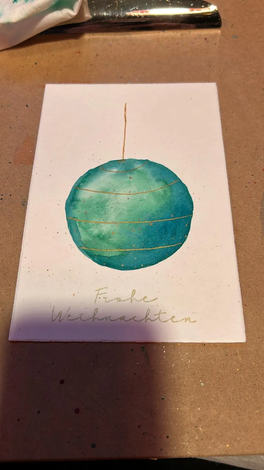 Handgemalte Karte mit Weihnachtskugeldesign.