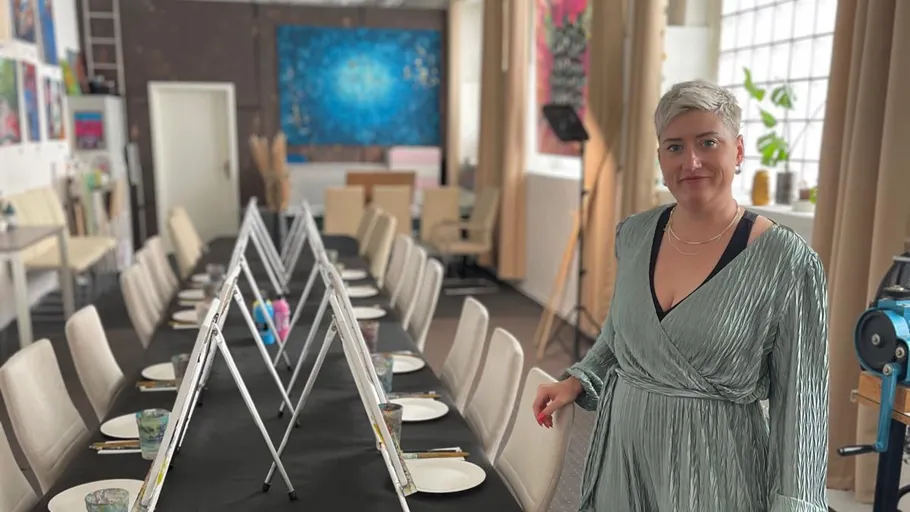 Person standing in art studio with painting setup.