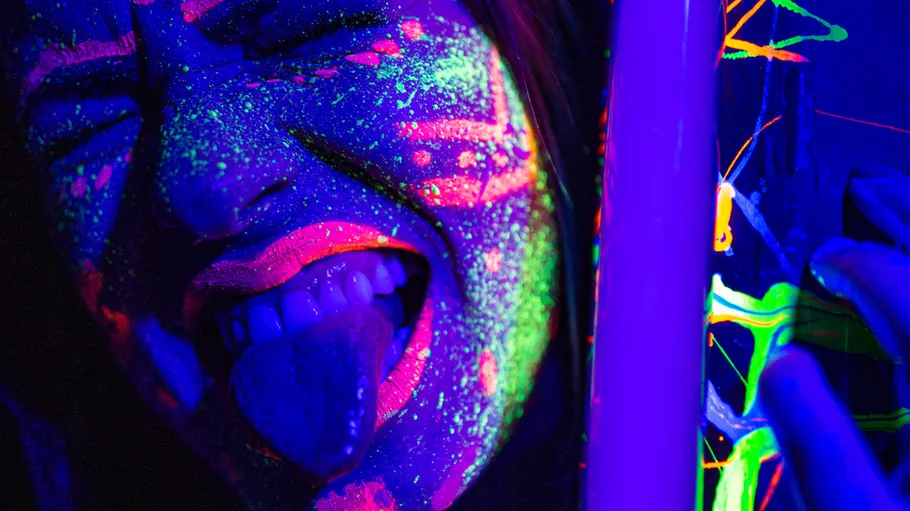 Person with neon paint under blacklight.