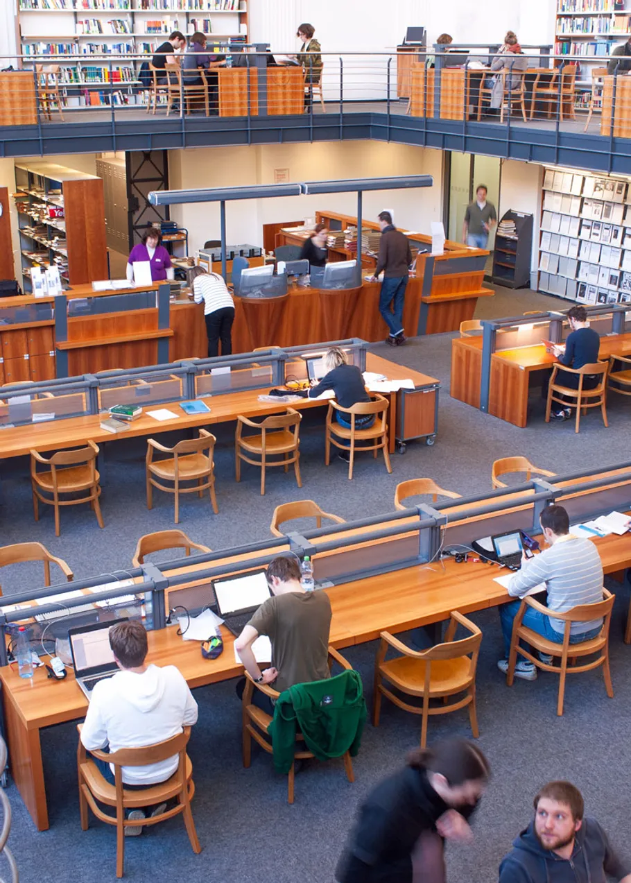 People studying in a two-level library.