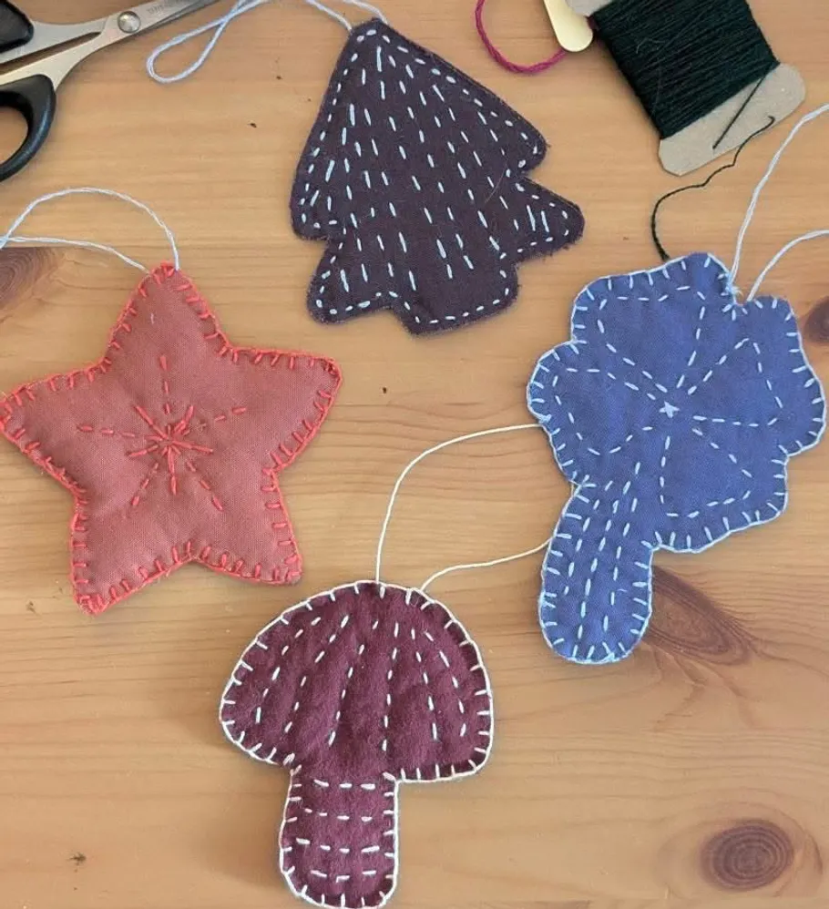 Fabric ornaments with stitching on table.