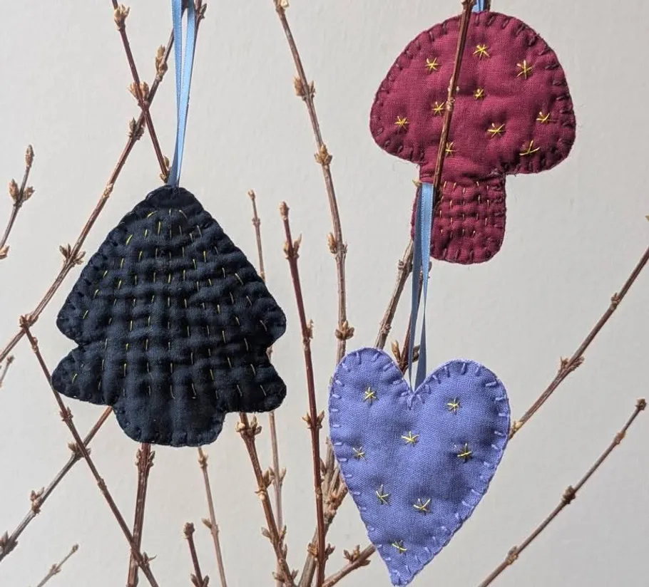 Fabric ornaments hanging on bare branches.
