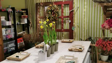 Blumenwerkstatt mit Narzissen auf Tisch.