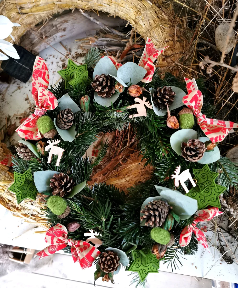 Decorative holiday wreath with pinecones and ribbons.