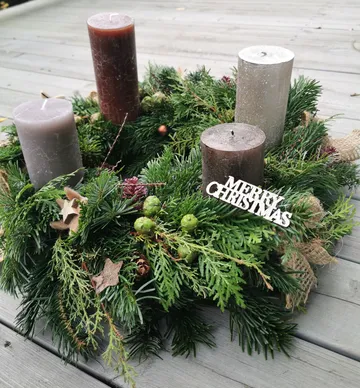 Advent wreath with candles on wooden table.