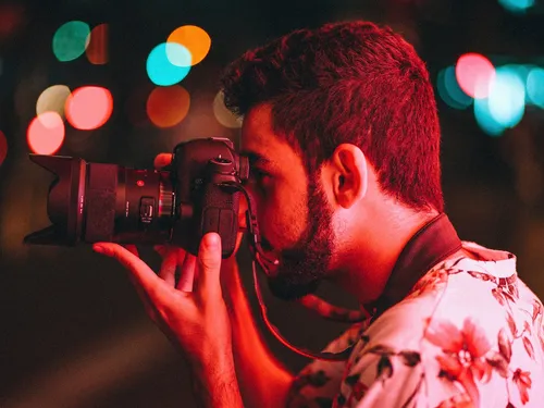 Ein Fotograf macht ein Bild vor einer nächtlichen Umgebung.