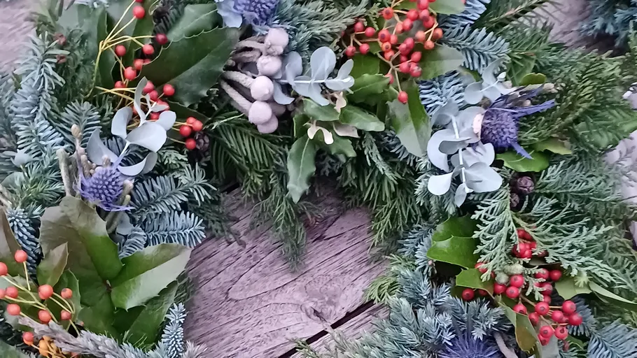 Decorative wreath with berries on wood surface.