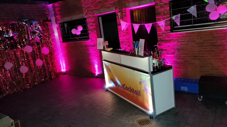 Baraufbau mit pinker Beleuchtung und Dekorationen.