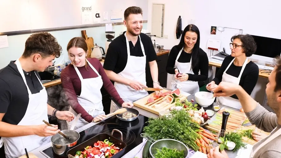 Gruppe kocht zusammen in einer Küche.
