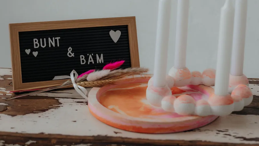 Letter board, colorful candles, and feathers on table.