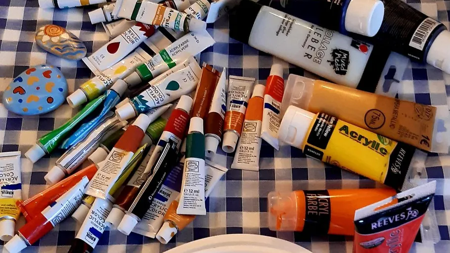 Art supplies on checkered tablecloth.