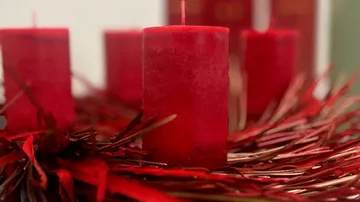 Rote Kerzen auf einem Adventskranz.