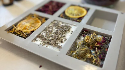 Herb-filled soap molds on a table.