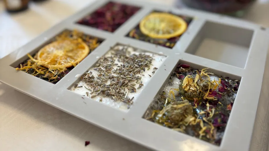 Herb-filled soap molds on a table.